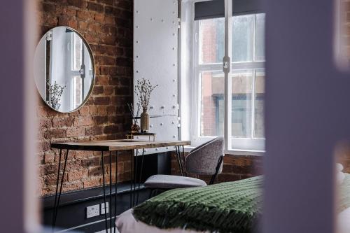 Cette chambre comprend un miroir, un lit et une table. dans l'établissement Host & Stay - Mathew St Studio, à Liverpool