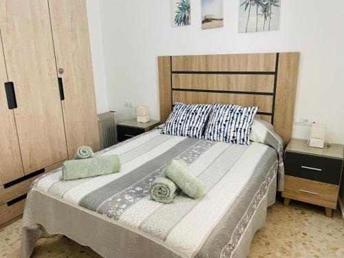a bedroom with a large bed with two pillows on it at Apartamento Conil Centro y Playa, descanso perfecto, con aire acondicionado y WIFI in Conil de la Frontera