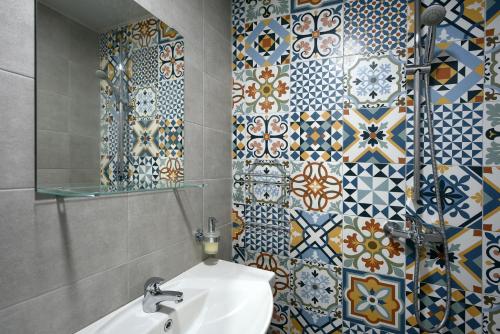 ein Badezimmer mit einem Waschbecken und einer Mosaikwand in der Unterkunft Villa Holiday in Baltschik