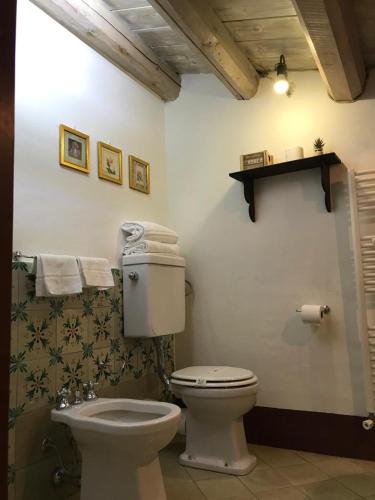 a bathroom with a toilet and a shelf on the wall at Antica Dimora San Girolamo in Licata