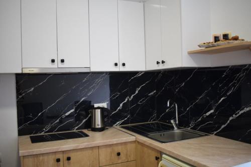 卡萨米尔Sunset Cottage 2的带白色橱柜和水槽的厨房