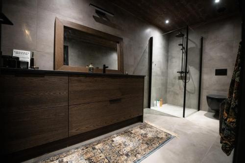 uma casa de banho com um lavatório, um espelho e um chuveiro em Ny luksus leilighet -ski in out i Hemsedal Skarsnuten 905 em Hemsedal