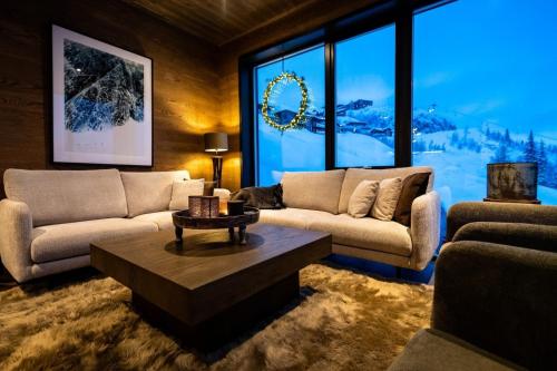 uma sala de estar com dois sofás e uma mesa em Ny luksus leilighet -ski in out i Hemsedal Skarsnuten 905 em Hemsedal