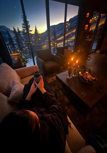 a person laying on a couch in a living room with a view at Ny luksus leilighet -ski in out i Hemsedal Skarsnuten 905 in Hemsedal