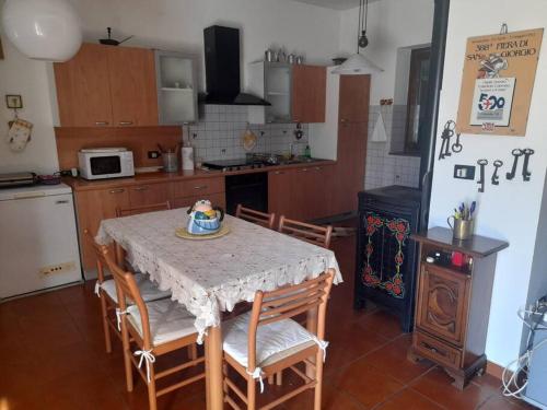 una cucina con tavolo e sedie e una cucina con piano cottura di Da Mariuccia a Rivalta Scrivia