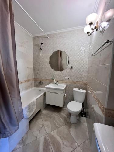 een badkamer met een toilet, een wastafel en een bad bij Видовая 1 ком на Осокорках in Kiev