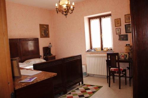 Da Mariuccia في Rivalta Scrivia: غرفة نوم بسرير ومكتب وطاولة
