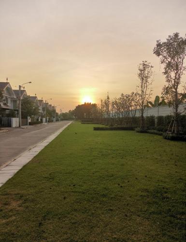 eine leere Straße mit Sonnenuntergang im Hintergrund in der Unterkunft บ้านพักใกล้สุวรรณภูมิ​ แอร์​พอร์ต​ลิงค์​ลาดกระบัง​ in Ban Khlong Lat Bua Khao