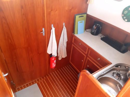 a small kitchen with a sink and a fire extinguisher at Motor Yacht Amazone in Amsterdam