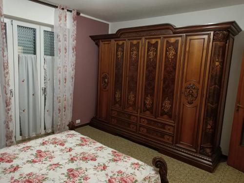 a bedroom with a bed and a large wooden cabinet at Gfamily affittacamere in Alba