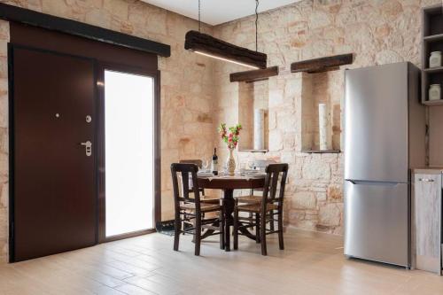 a kitchen with a table with chairs and a refrigerator at Villa Õtium in Epáno Váthia