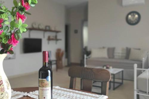 a bottle of wine sitting on a table in a living room at Villa Õtium in Epáno Váthia