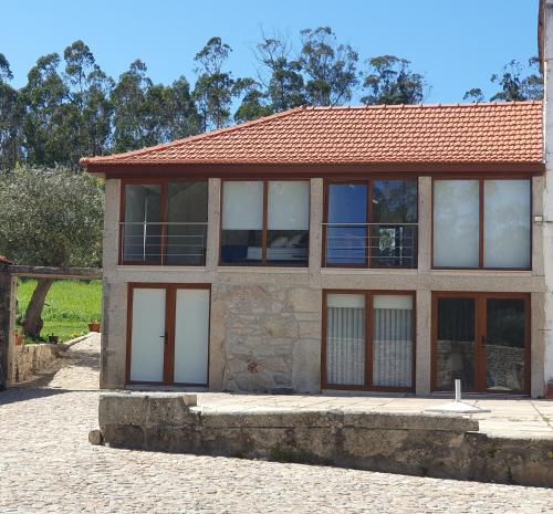 una casa con ventanas y techo rojo en Casa do Forno de Cal, en Vila do Conde