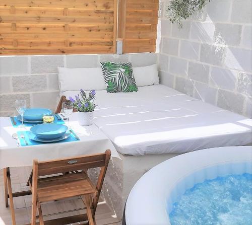 um pátio com uma mesa e uma banheira de hidromassagem em La Calita Escondida - Jacuzzi y Cocina en Terraza Privada - Piscina y Parking Gratis em Chiclana de la Frontera
