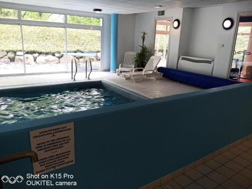 a swimming pool in a building with a sign in front of it at Le Repaire du Golfeur de la Largue - Mooslargue in Mooslargue