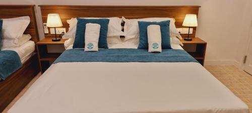 a bedroom with a bed with blue and white pillows at Vaagali Inn in Keyodhoo