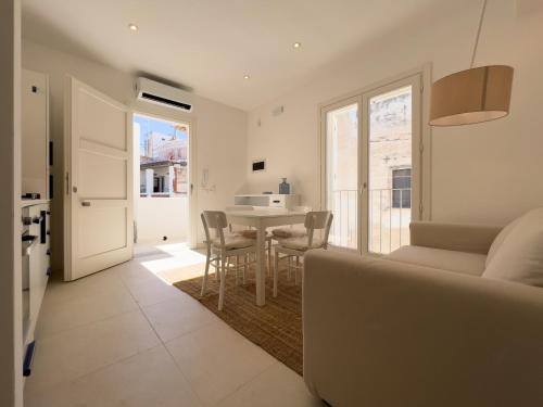 a living room with a couch and a table with chairs at Maruzza Home in Favignana
