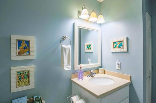 a bathroom with a sink and a mirror at Mermaid’s Folly in Folly Beach