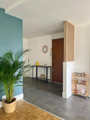 a room with a table and a plant in it at Chambre privée dans un appartement partagé in Villeurbanne