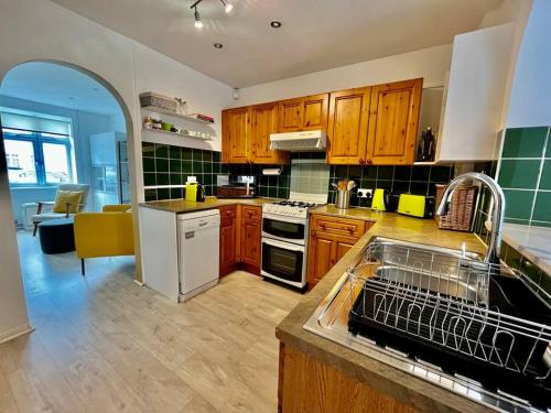 uma cozinha com um lavatório e uma máquina de lavar louça em Entire 3 Bed House Weybridge Brooklands, London em Byfleet
