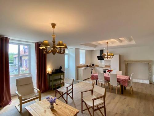 a living room with a table and chairs and a kitchen at Maison avec piscine au calme 