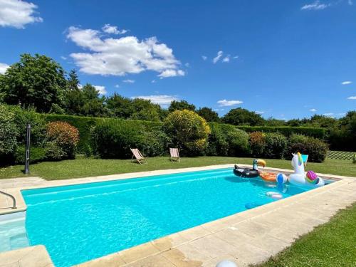 a swimming pool with a pool noodle in a yard at Maison avec piscine au calme 