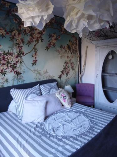 Schlafzimmer mit einem Bett mit einer blauen und weißen Bettdecke in der Unterkunft LES BIGORNEAUX in Saint-Suliac