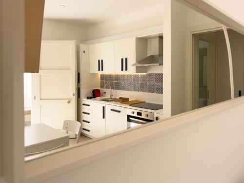 una cocina blanca con armarios blancos y una escalera en Maruzza Home en Favignana