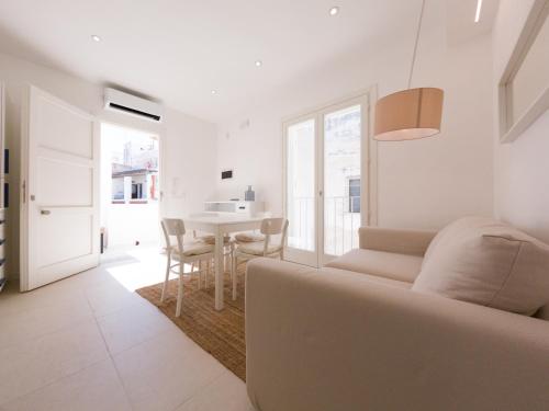 a white living room with a couch and a table at Maruzza Home in Favignana