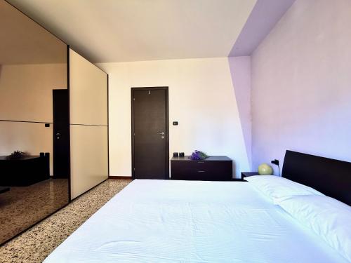 a bedroom with a white bed and a black door at Casa da Ste in Mandello del Lario