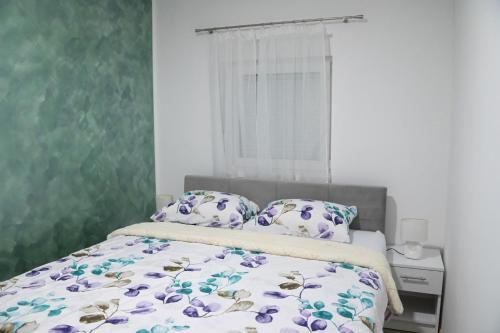 トレビニェにあるApartmani DAR Trebinjeのベッドルーム1室(紫色の花のベッド1台付)