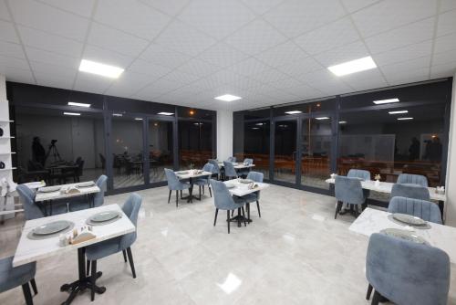 a dining room with tables and chairs and windows at White House Cappadocia in Nevşehir