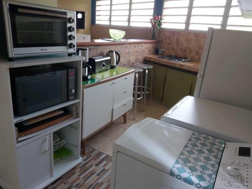 a kitchen with a microwave oven and a stove at Villa verte in Le Robert