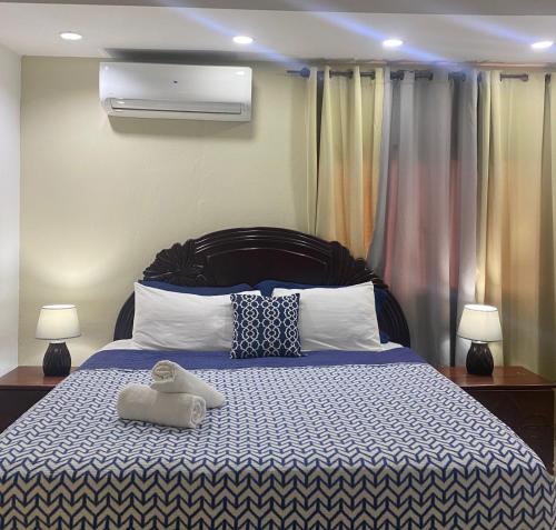 um quarto com uma cama azul e branca com 2 candeeiros em Hotel Boutique Simona em La Romana