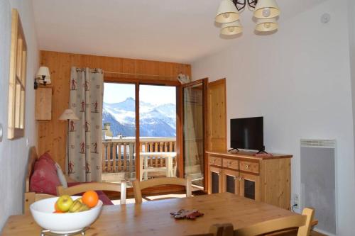 una sala de estar con una mesa con un bol de fruta en T2 6 p - Pieds des pistes - résidence avec piscine en Orcières