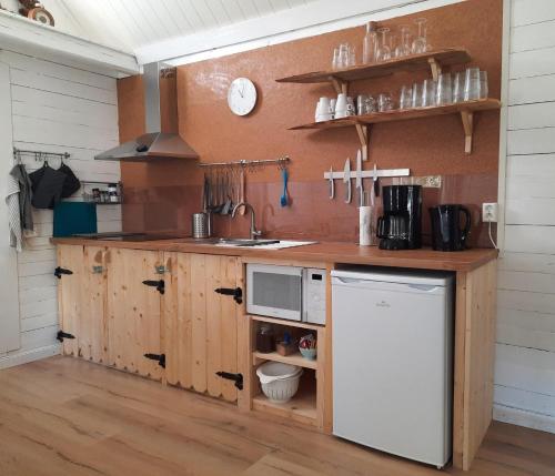 a kitchen with wooden cabinets and a white refrigerator at Davids Stuga in Klässbol