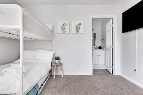 a white bedroom with a bunk bed and a kitchen at Near Downtown l Peaceful l Modern l Kids Room in Atascadero