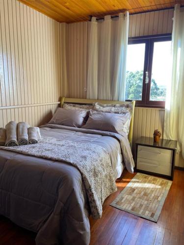 ein großes Bett in einem Schlafzimmer mit Fenster in der Unterkunft Mountain House in Bom Jardim da Serra