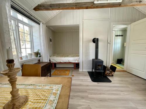 a living room with a fireplace and a bedroom at Idyllic small farm appartment in Tønsberg