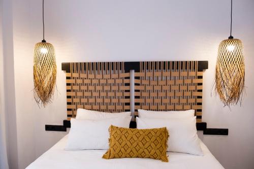 a bedroom with a bed with two lights above it at VENUS LUXURY APARTMENT in Ermoupoli
