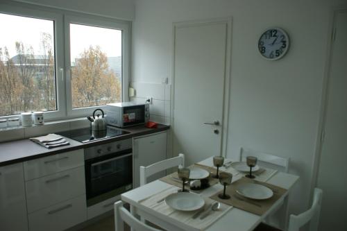 eine Küche mit einem Tisch und einer Uhr an der Wand in der Unterkunft Apartment Majatalo in Zagreb