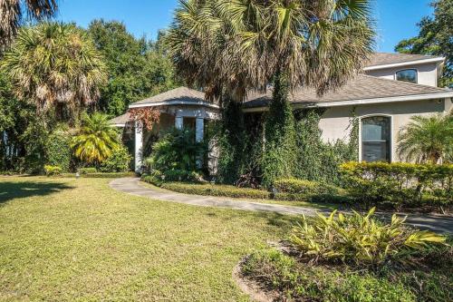 a house with a palm tree in a yard at Florida Space Coast Waterfront Retreat in Cocoa