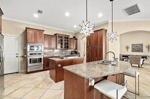 a kitchen with wooden cabinets and a island with a sink at Florida Space Coast Waterfront Retreat in Cocoa