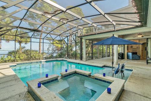 ein großer Pool mit einem Sonnenschirm und einem Innenpool in der Unterkunft Florida Space Coast Waterfront Retreat in Cocoa