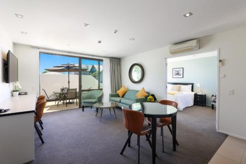 a living room with a couch and a bed and a table at Palazzo Motor Lodge in Nelson