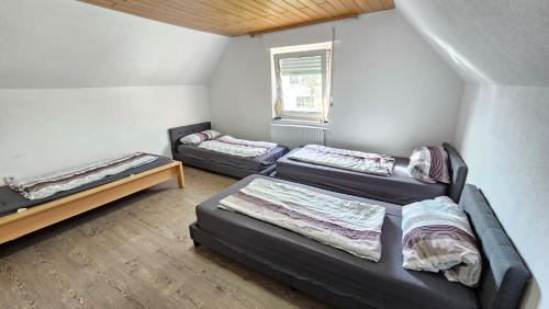 Zimmer mit 3 Betten und einem Fenster in der Unterkunft Haus Mitten in Herzen von Günzburg in Günzburg