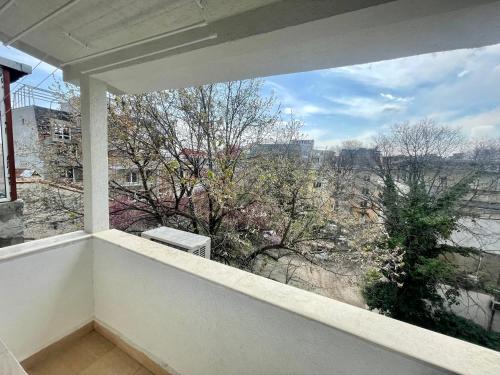 a balcony with a large window looking out at a city at GlassRoom- Самостоятелна стая Private room in Varna City