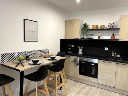 cocina con mesa, sillas y barra en Bel appartement sur cour plein centre ville et parking, en Moulins