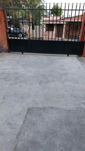 a parking lot with a black fence and a parking meter at Tocumen Sweet Home in Cabuya