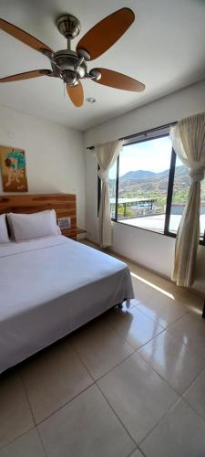 a bedroom with a bed and a ceiling fan at Casa Italia Guest House in Taganga